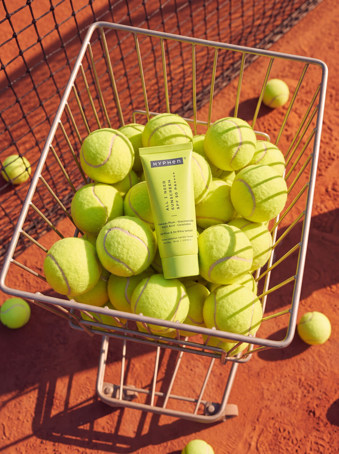 HYPHeN tube resting in a ball cart full of tennis balls