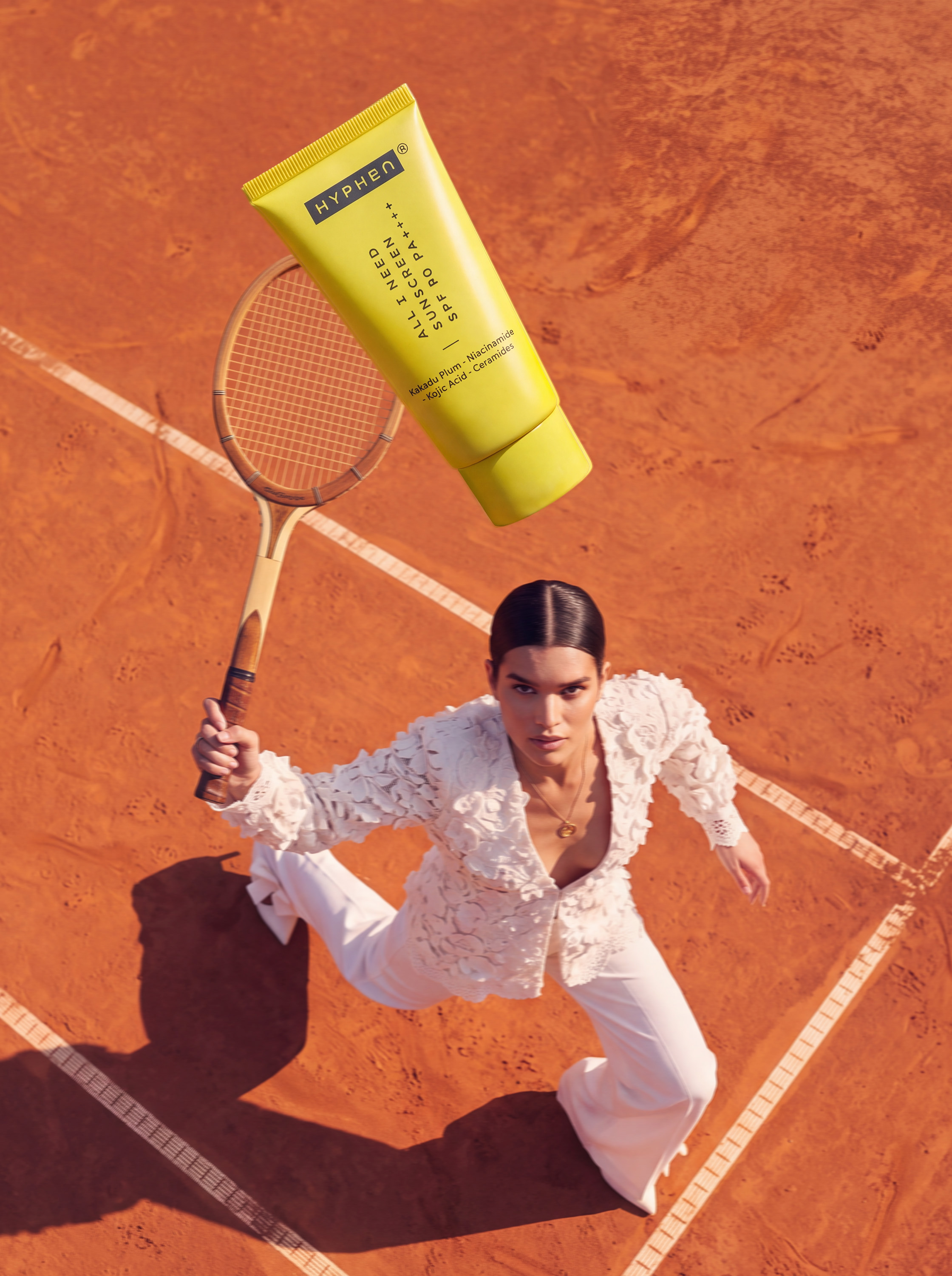 Overhead action shot — model on clay court, HYPHeN tube in foreground